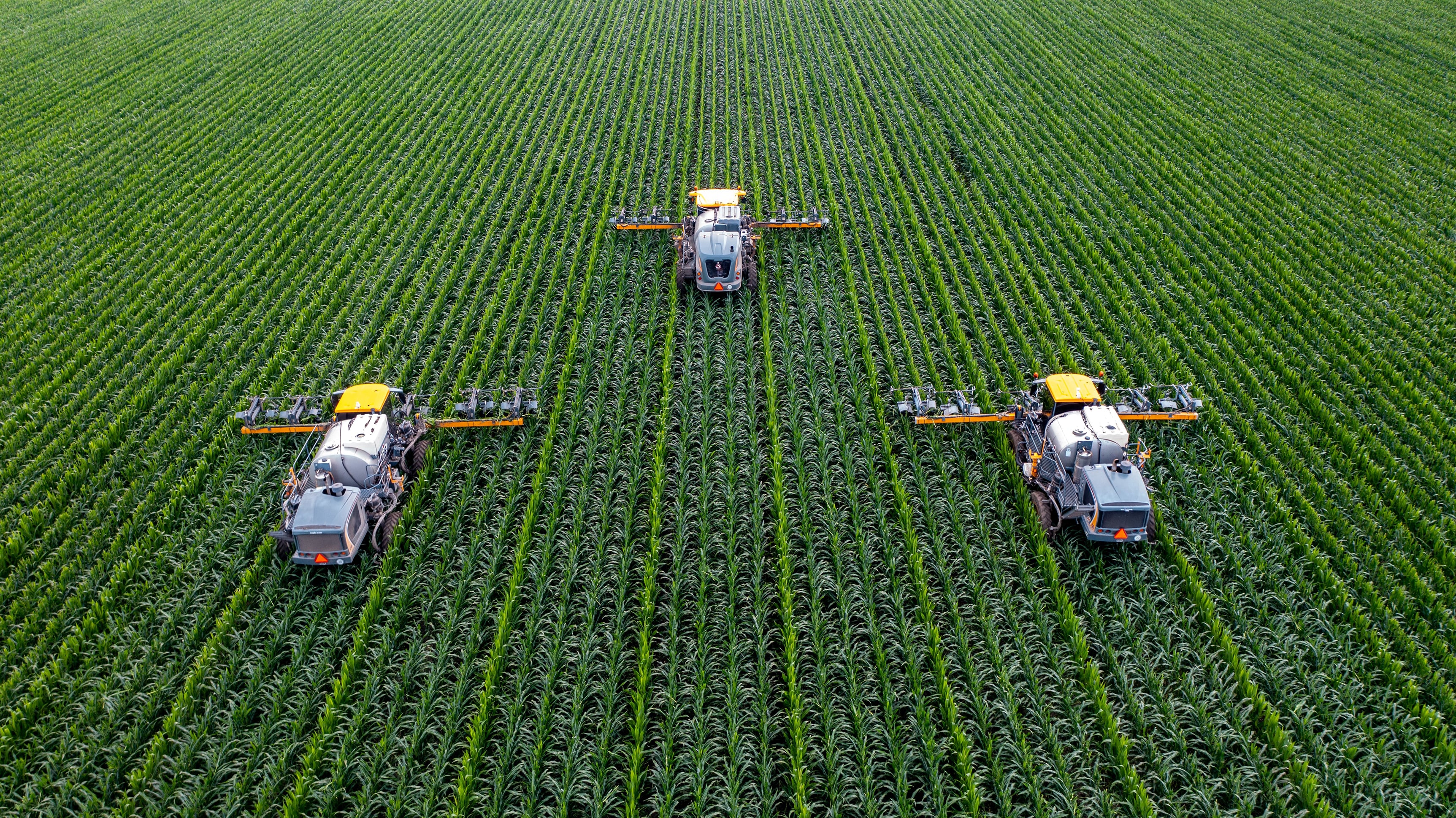 Three tractors combing a farmland
